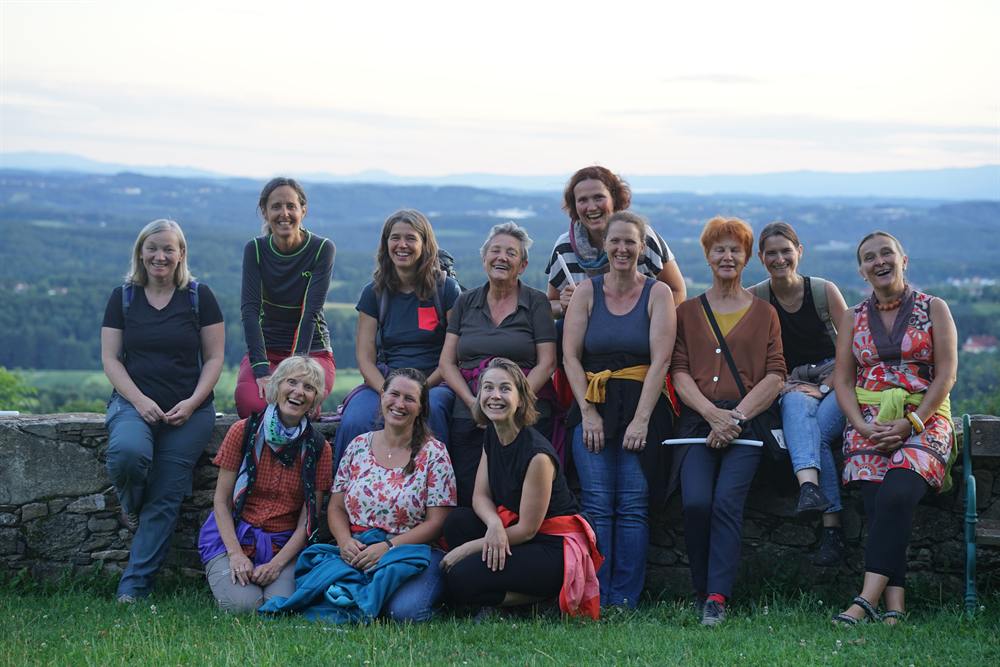 Eine Frauengruppe im Abendlicht vor weiter Landschaft